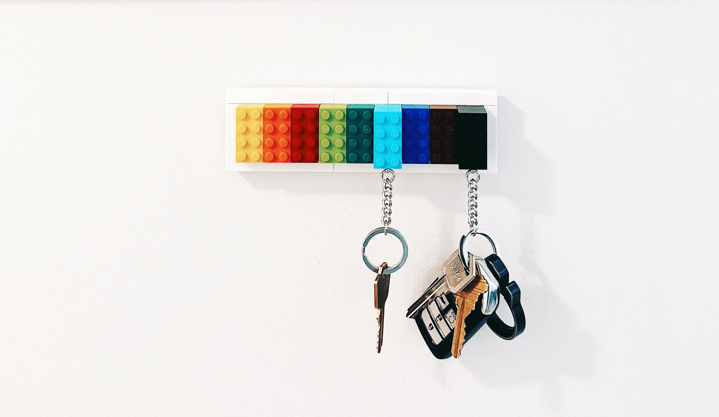 Keys hanging from a lego brick used as a keychain attached to some lego bricks on the wall