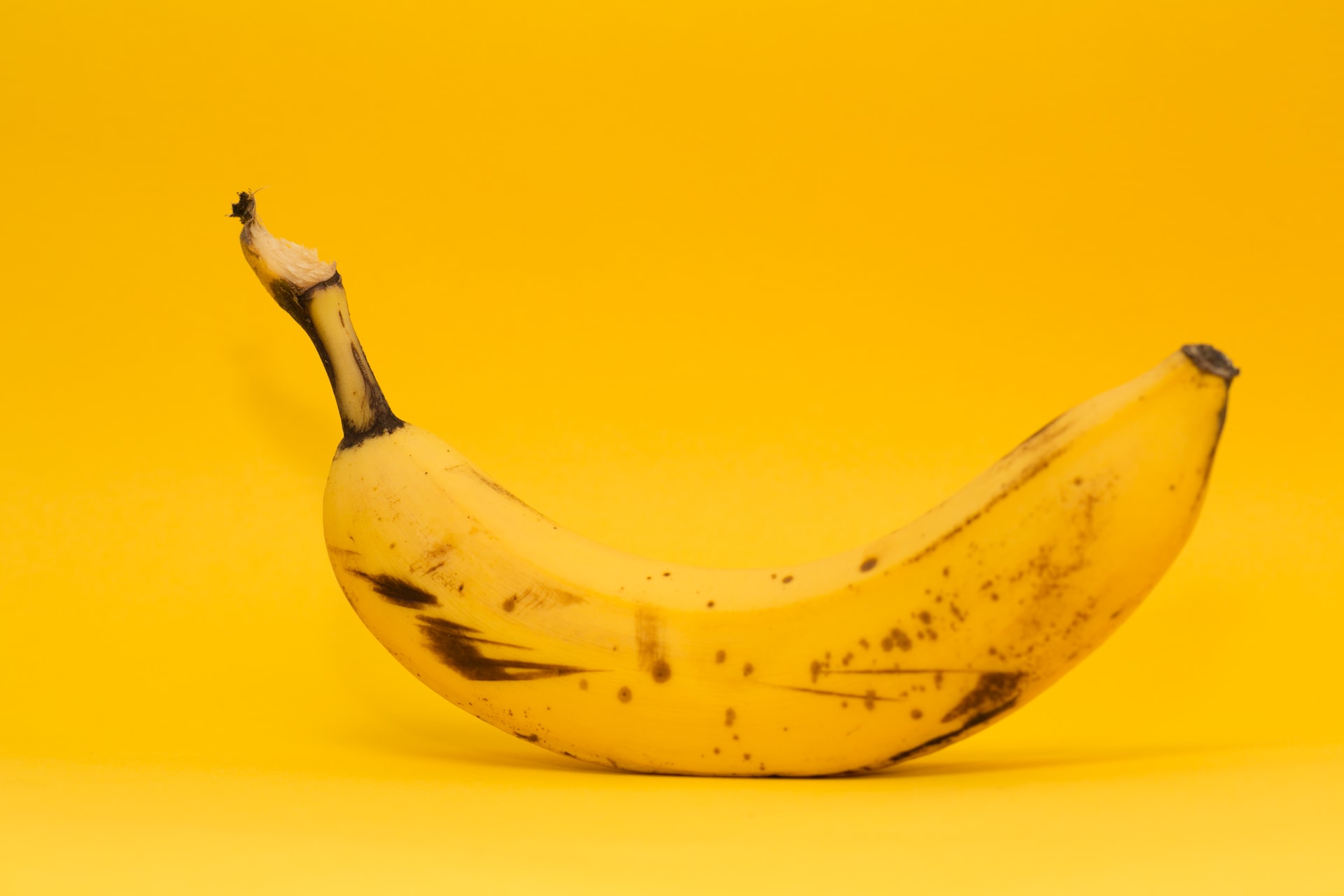 A ripe banana on a yellow background